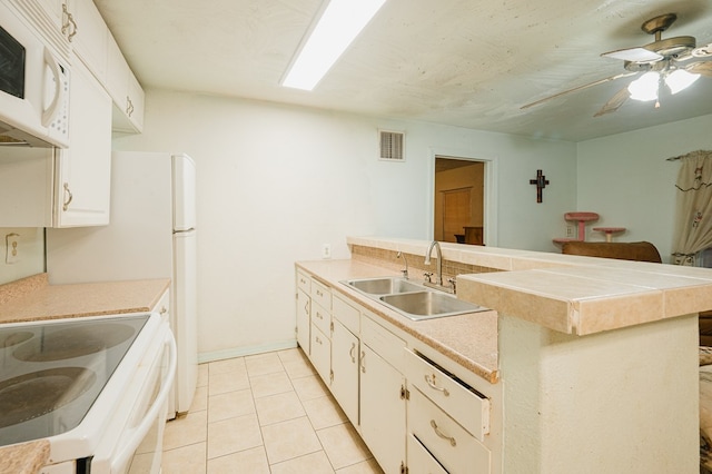 kitchen with visible vents, light countertops, light tile patterned flooring, a sink, and a peninsula