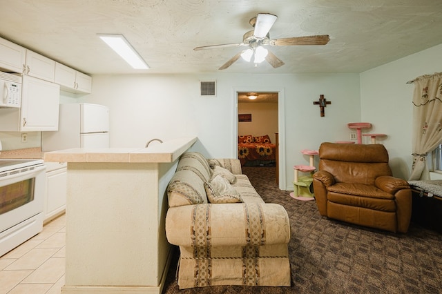 living area with visible vents, ceiling fan, a textured ceiling, and light tile patterned flooring