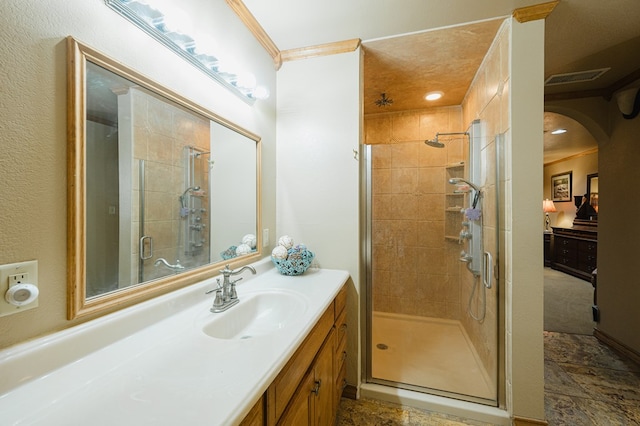 bathroom featuring vanity, ornamental molding, a shower stall, and visible vents