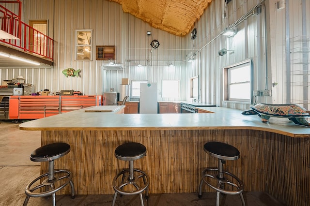 kitchen with lofted ceiling, a peninsula, and a breakfast bar