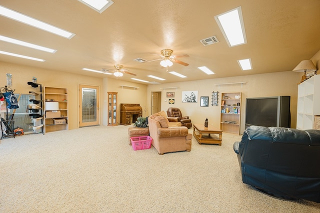 carpeted living area with a ceiling fan, visible vents, and a fireplace