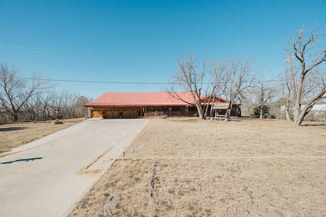 single story home featuring metal roof, driveway, and a carport