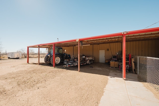 view of vehicle parking with a carport and fence