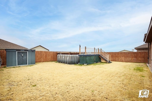 view of yard featuring a fenced in pool and a storage unit