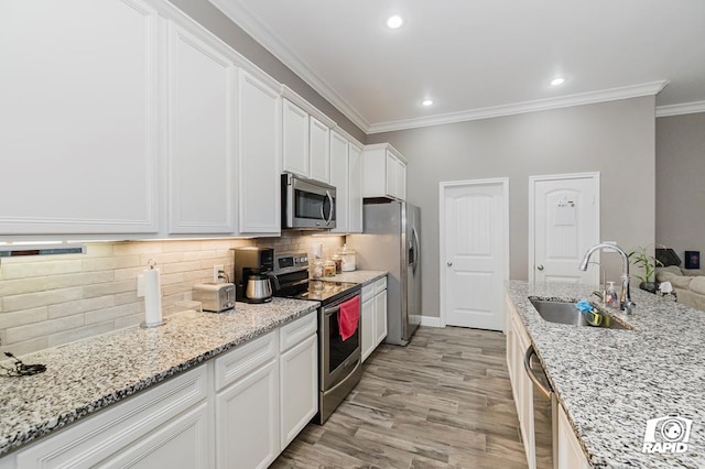 kitchen featuring sink, crown molding, stainless steel appliances, light stone countertops, and white cabinets