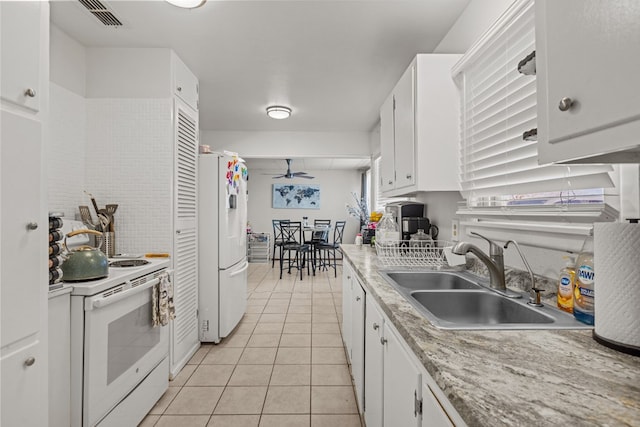 kitchen featuring sink, white appliances, light tile patterned floors, ceiling fan, and white cabinets