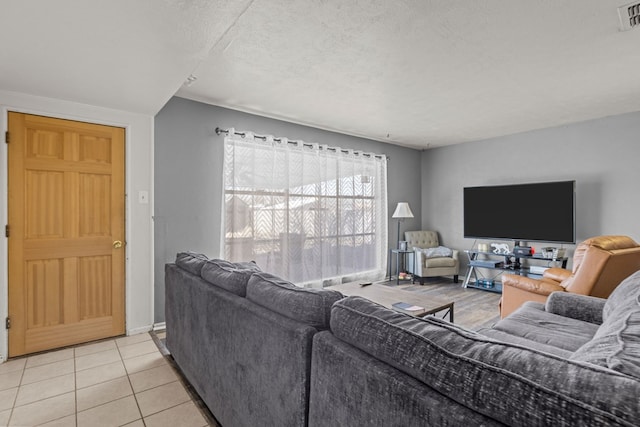 living room featuring a textured ceiling and light tile patterned floors