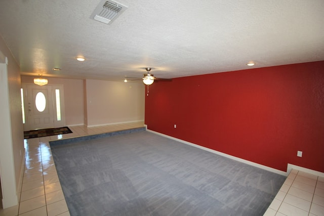 interior space featuring a textured ceiling, tile patterned floors, and ceiling fan