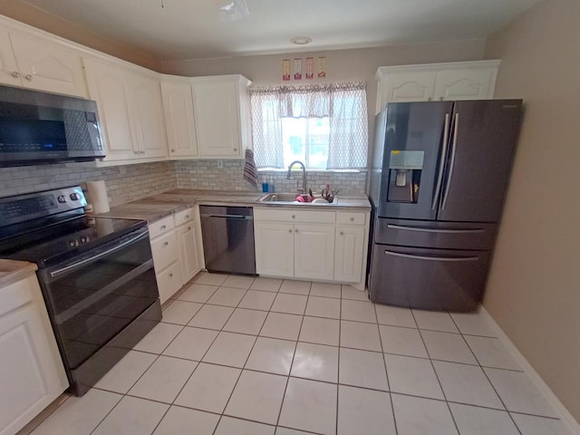 kitchen with sink, stainless steel appliances, light tile patterned floors, tasteful backsplash, and white cabinets