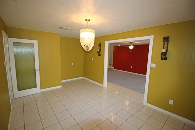 spare room with light tile patterned flooring and a chandelier