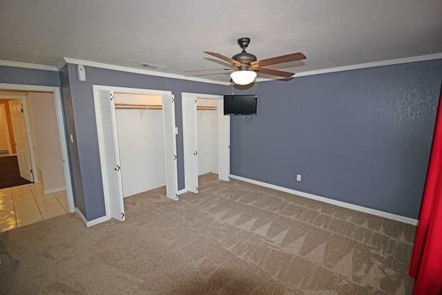 unfurnished bedroom with carpet, a textured ceiling, ceiling fan, and ornamental molding