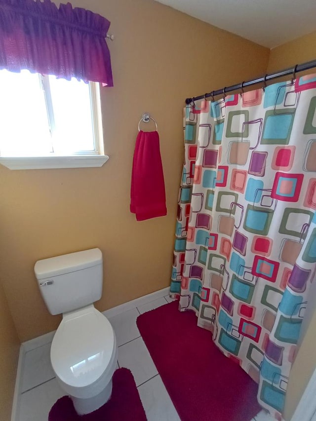 bathroom with tile patterned flooring, toilet, and walk in shower