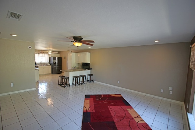 unfurnished living room featuring sink and light tile patterned flooring