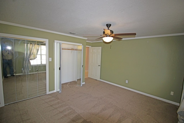 unfurnished bedroom featuring carpet flooring, a textured ceiling, ceiling fan, and crown molding