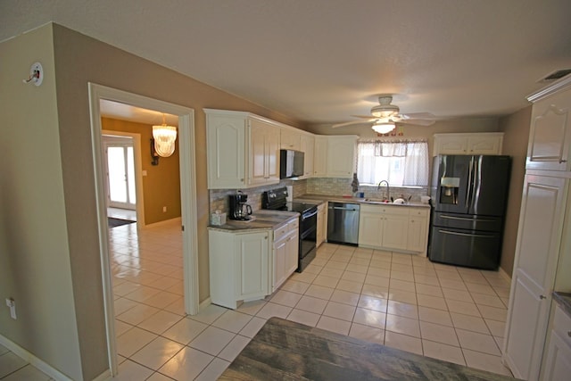 kitchen with appliances with stainless steel finishes, tasteful backsplash, sink, white cabinetry, and light tile patterned flooring