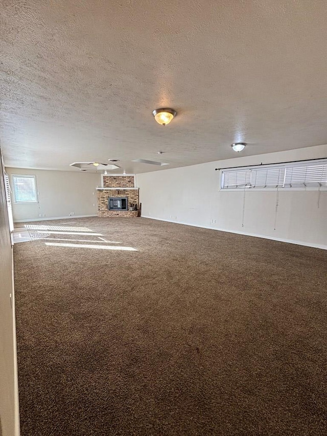 carpeted spare room featuring a fireplace and a textured ceiling