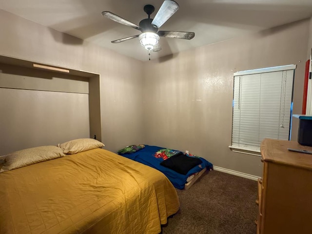 bedroom featuring ceiling fan and dark carpet