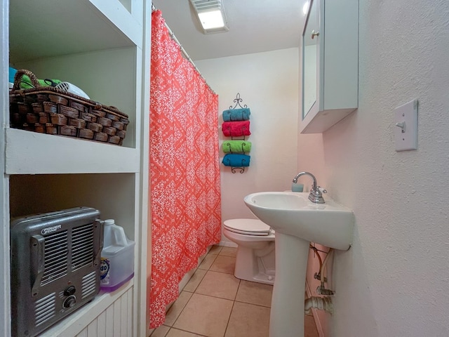 bathroom featuring toilet and tile patterned floors