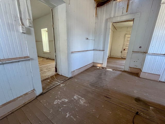 empty room with wood-type flooring and wooden walls