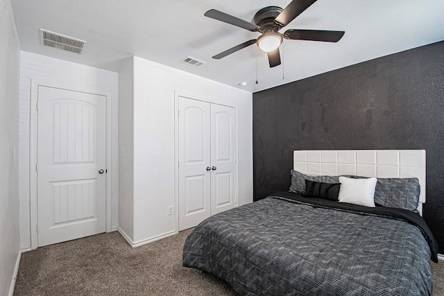 carpeted bedroom featuring a closet, visible vents, baseboards, and ceiling fan