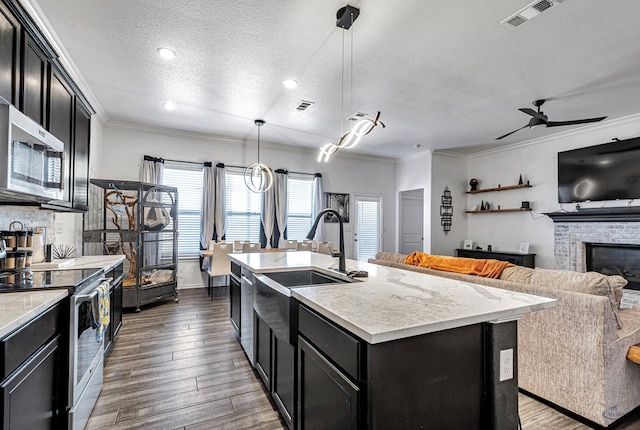 kitchen featuring crown molding, visible vents, dark cabinets, and stainless steel appliances