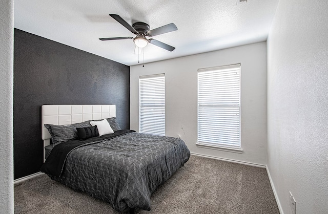 bedroom featuring baseboards, a textured ceiling, carpet flooring, and a textured wall