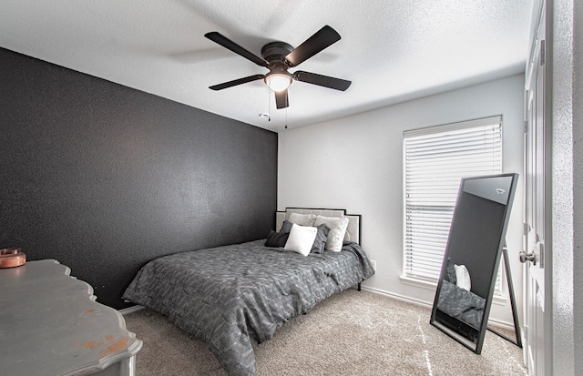 carpeted bedroom featuring baseboards, a textured ceiling, ceiling fan, and a textured wall