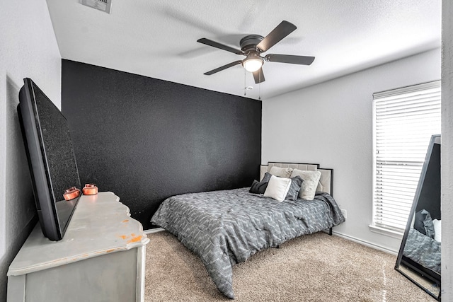 bedroom with a textured ceiling, carpet, baseboards, ceiling fan, and a textured wall