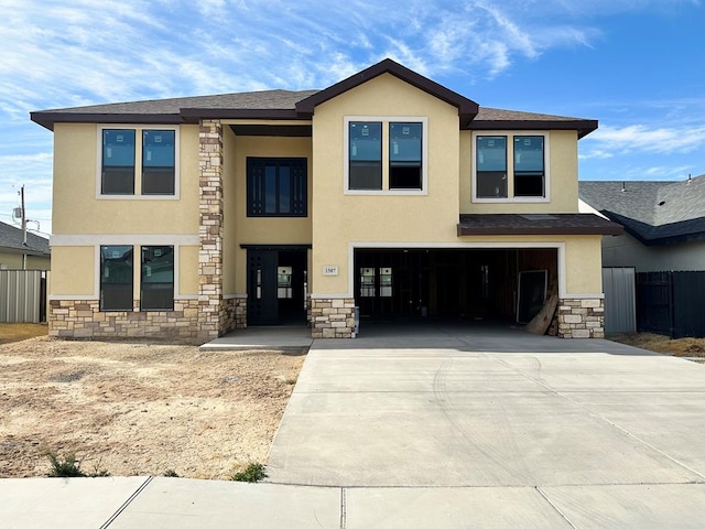 view of front facade featuring a garage, stone siding, driveway, and stucco siding