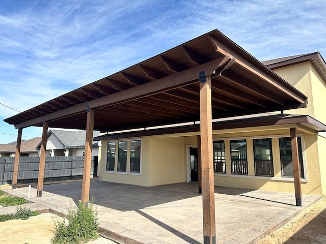 back of property with fence and stucco siding