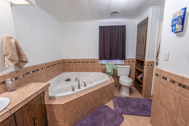 bathroom featuring tile patterned floors, toilet, tile walls, vanity, and tiled bath