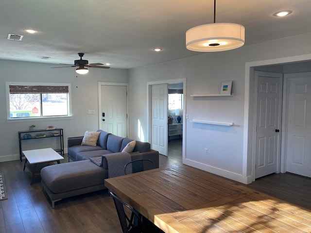 living room with ceiling fan and dark wood-type flooring