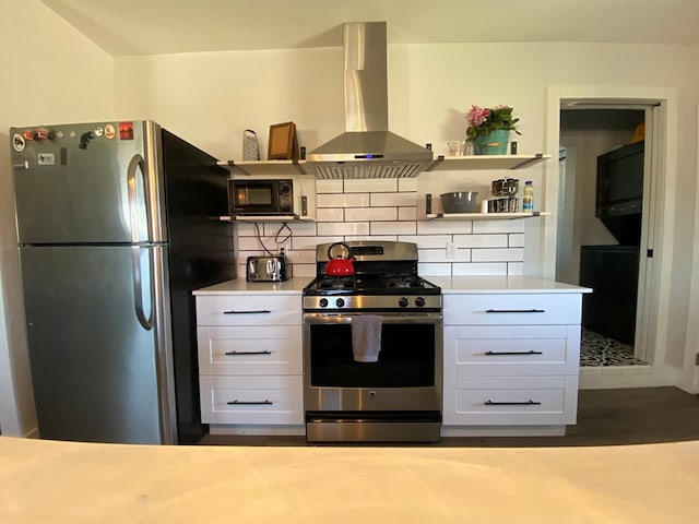 kitchen featuring decorative backsplash, stainless steel appliances, white cabinetry, and wall chimney exhaust hood