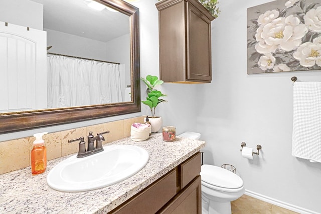 bathroom with tile patterned flooring, vanity, and toilet