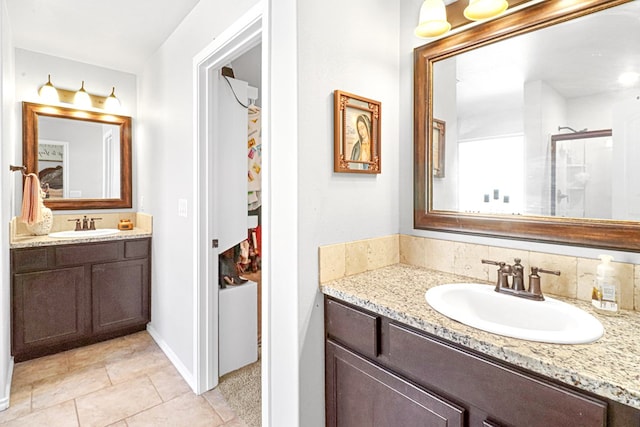 bathroom with tile patterned floors, vanity, an enclosed shower, and backsplash