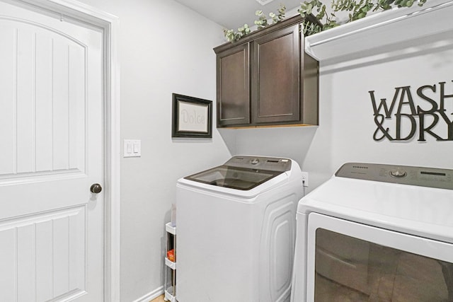 washroom featuring cabinets and independent washer and dryer