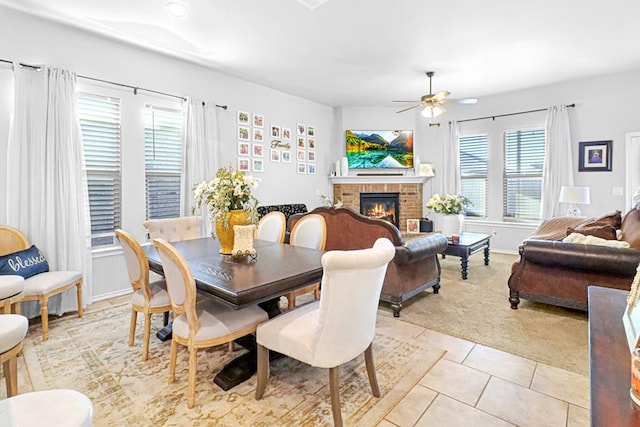 carpeted dining area featuring plenty of natural light, ceiling fan, and a brick fireplace