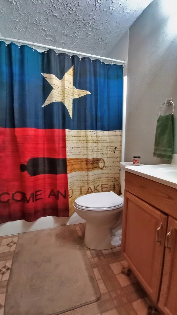 bathroom with vanity, a shower with shower curtain, and toilet