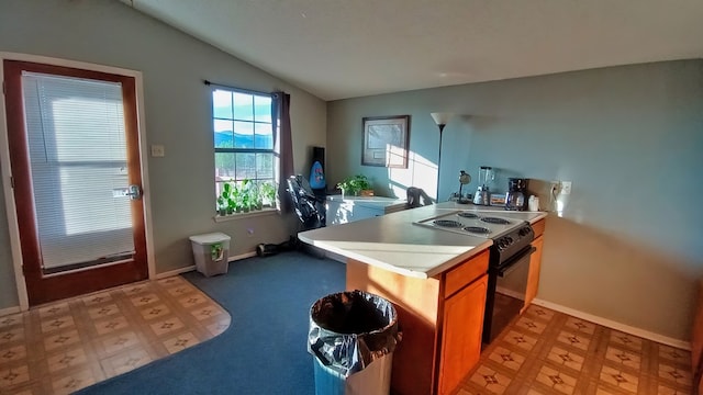 kitchen featuring kitchen peninsula, electric range, and vaulted ceiling