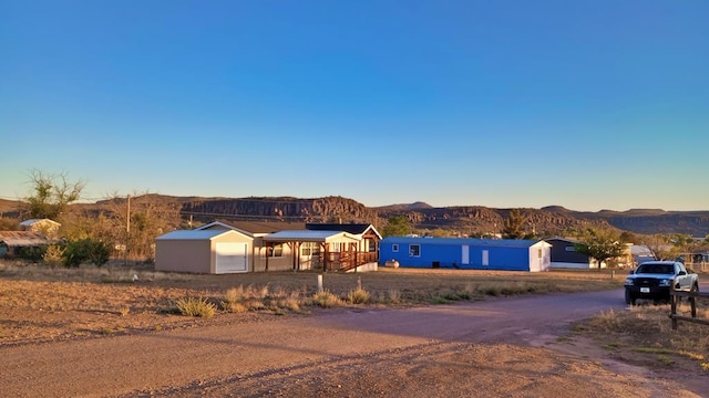 view of front of property featuring a mountain view, a garage, and an outdoor structure