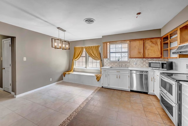 kitchen featuring sink, white cabinetry, tasteful backsplash, decorative light fixtures, and stainless steel appliances