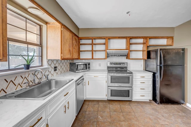 kitchen featuring sink, white cabinetry, ventilation hood, appliances with stainless steel finishes, and backsplash