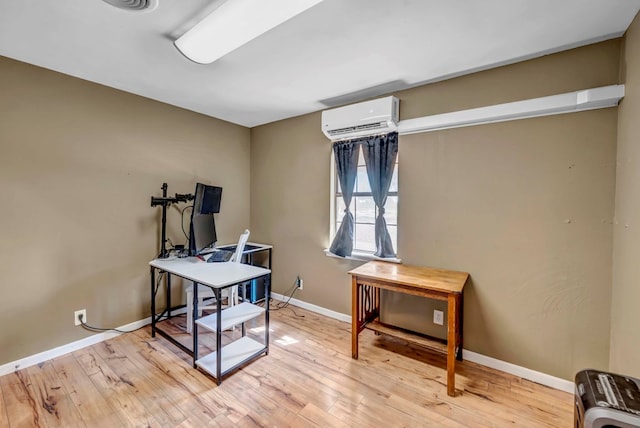 office area with light hardwood / wood-style floors and an AC wall unit