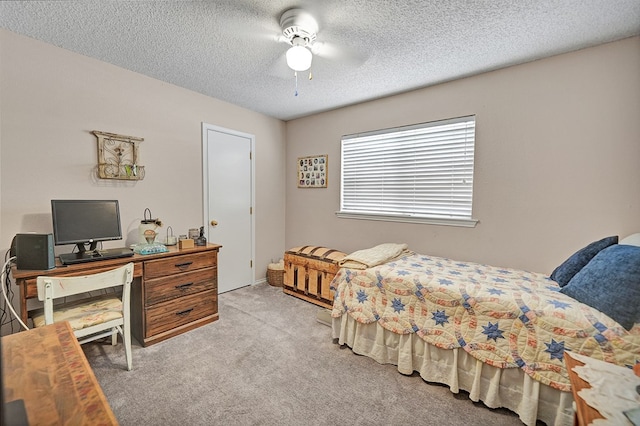 bedroom with ceiling fan, light colored carpet, and a textured ceiling