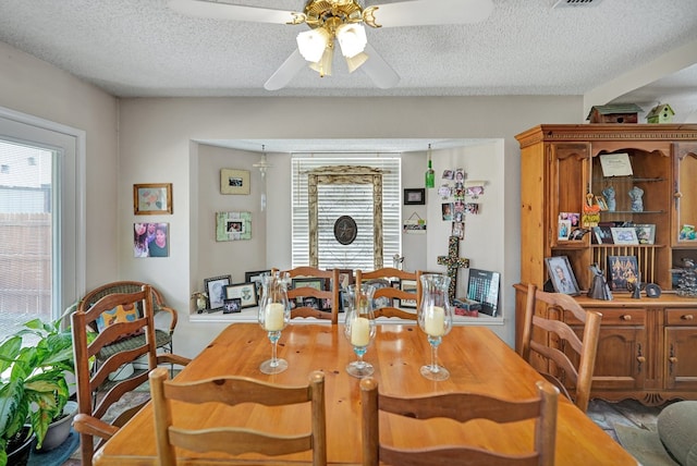 dining room featuring ceiling fan and a textured ceiling