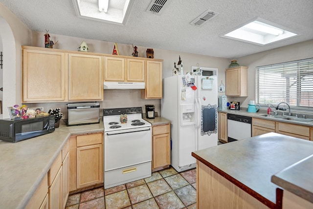 kitchen with a sink, white appliances, under cabinet range hood, and light brown cabinets