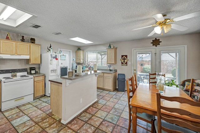 kitchen featuring white appliances, visible vents, under cabinet range hood, and light brown cabinetry