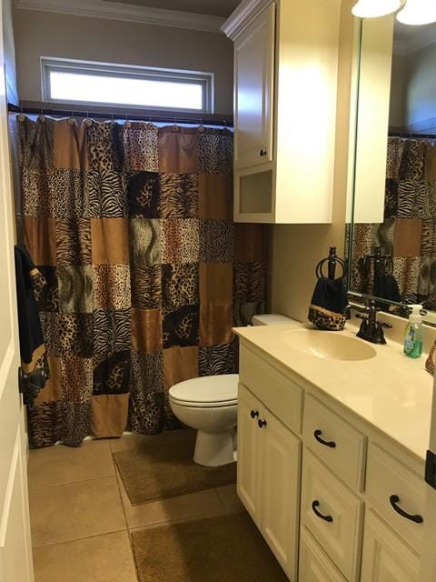 bathroom with crown molding, a healthy amount of sunlight, vanity, and tile patterned floors