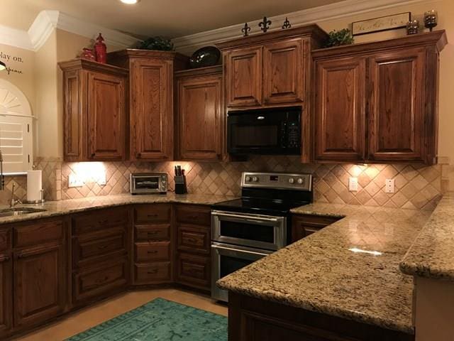 kitchen featuring double oven range, light stone counters, and decorative backsplash