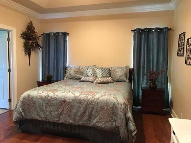 bedroom featuring crown molding and dark hardwood / wood-style floors